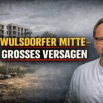 Mit grauem Brachgelände, Baustelle und dem Schriftzug „WULSDORFER MITTE – GROSSES VERSAGEN“ vor Dieckell in Bremerhaven von der Stadt.